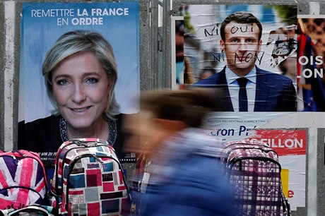 ena prochází kolem plakát Marine Le Penové a Emmanuela Macrona.