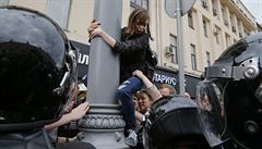 Jedna z protestujících je strhávána z lampy uprosted demonstrace v Moskv.