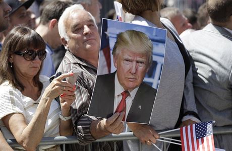 Mu fandící Trumpovi eká na jeho píjezd i s jeho velkoformátovou fotkou.