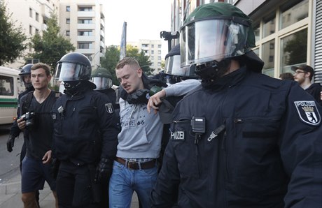 Policie odvádí jednoho ze zadrených.