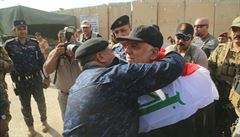 Irácký premiér oslavuje s vlajkou v Mosulu.