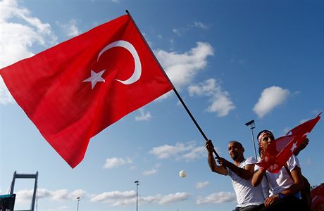 Lidé u Mostu muedník mávají tureckými vlajkami.