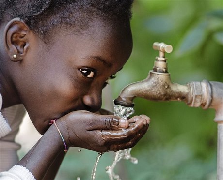 Africká dívka pijící vodu.