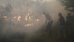 Místní obyvatelé se pokouí uhasit ohe.