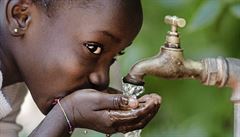 Africká dívka pijící vodu.