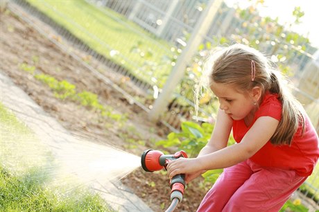 Dívka zalévá zahradu (ilustrační foto)
