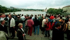Lidé sledují rozvodnnou Vltavu.