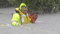 Wilford Martinez, vpravo, je zachránn ze zatopeného auta místním erifem,...