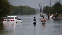Místní lidé v Hustonu se snaí dostat skrze povodovou vodu.