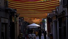 Lidé procházejí pod katalánskými vlajkami poblí Barcelony.