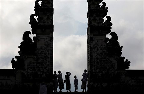 Baliané vyhlíející na oblaka vystupující ze sopky Agung.