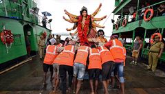 Dlnící odnáejí modlu bohyn Durga, aby ji ponoily do vody v ece Brahmaputra.