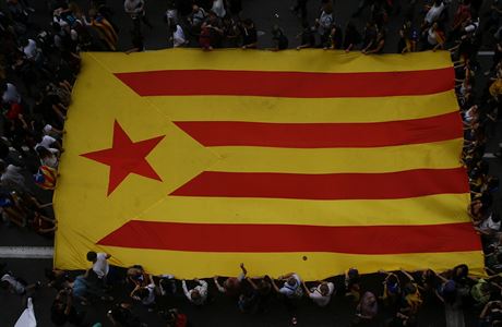 Demonstranti, protestující v íjnu, drí katalánskou vlajku.