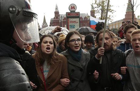 Policist blokujc demonstranty pi protestech v Moskv.
