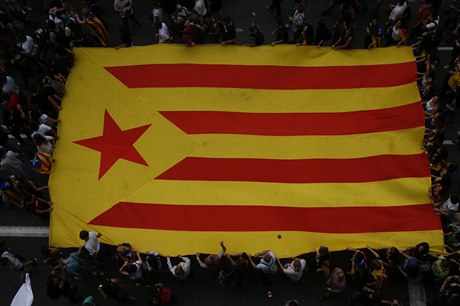 Demonstranti drí katalánskou vlajku.