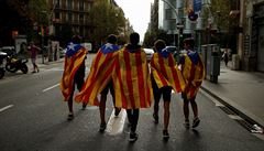 Studenti zabalení v katalánské vlajce kráí ulicí.