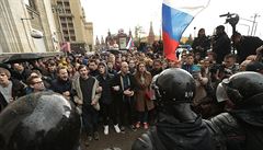 Policie blokující skandující demonstranty pi protestu v Moskv.