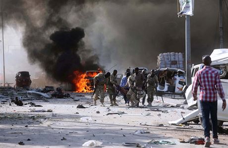 Syrská armáda odnáí jednoho ze svých koleg od místa, kde explodovalo auto.