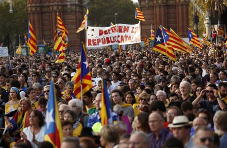 Lidé s katalánskými vlajkami během shromáždění v Barceloně.