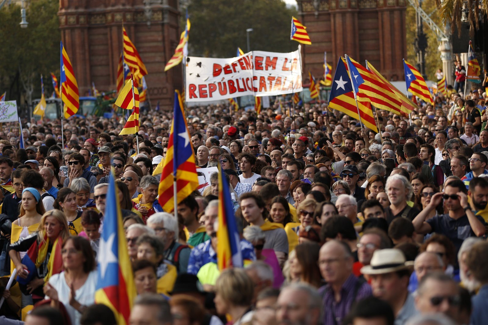 Lidé s katalánskými vlajkami během shromáždění v Barceloně.