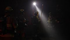 Kaliforntí hasii stojí ped budovou znienou poárem.