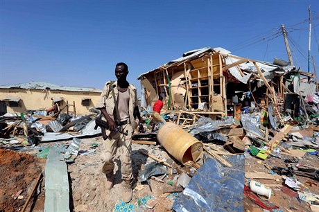 Voják somálské vlády prochází pes místo, kde se odpálil sebevrah.