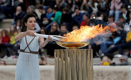 Herečka Katerina Lehou zapaluje olympijskou pochodeň.
