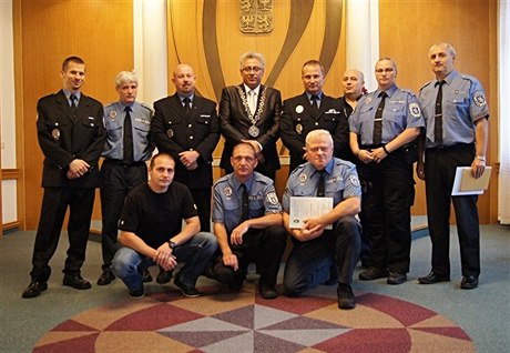 Na snímku z předání vyznamenání je i strážník Martin Roučka (první zleva v dolní řadě, v černém triku).