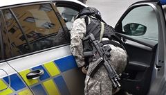 Policejní zásahová jednotka se chystá vniknout do bytu.