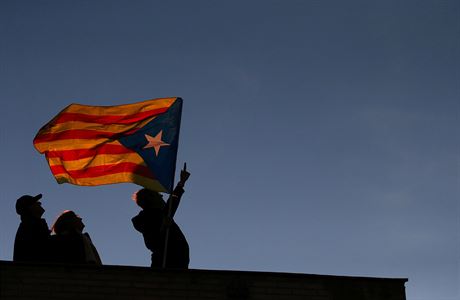 Lidé s katalánskou vlajkou na demonstraci za proputní katalánských politik.