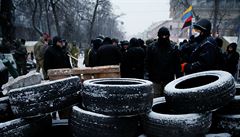 Demonstranti staví bariéry z pneumatik ped budovou parlamentu.