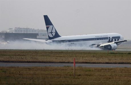 Boeing 767.v oblacích dýmu kloue po ranveji varavského letit.