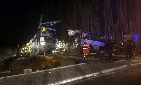 Záchranái a hasii u nehody vlaku a autobusu.