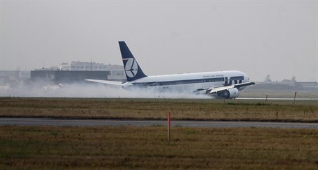 Boeing 767.v oblacích dýmu kloue po ranveji varavského letit.