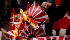 Protestující pálí fotografie japonského premiéra.