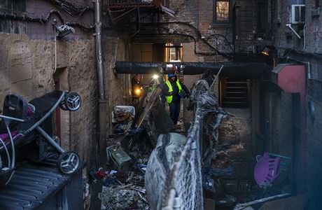 Policejní vyetovatelé procházejí trosky vyhoelého domu v newyorské tvrti...