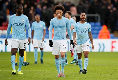 Fotbalisté Manchesteru City odcházejí ze hřiště se sklopenou hlavou.