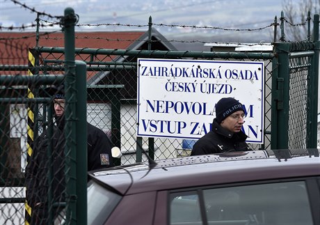 Policisté hlídají 8. ledna vjezd do zahrádkáské osady eský Újezd mezi...