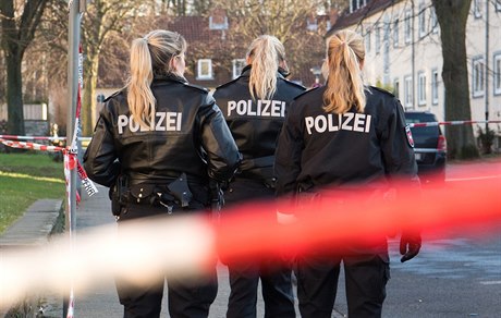 Policisté za páskou ohraniující místo, kde byla zastelena dvanáctiletá dívka.