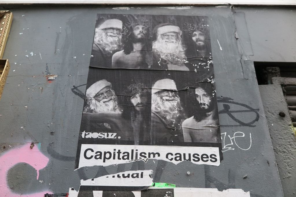 Plakát na londýnské zdi hlásá, že kapitalismus způsobuje duchovní úpadek...