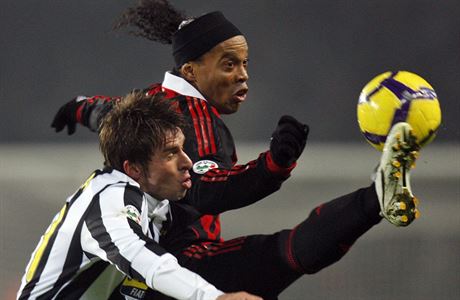 Ronaldinho v dresu AC Milán bojuje o mí s obráncem Juventusu Zdekem Grygerou.