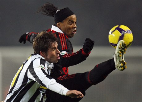 Ronaldinho v dresu AC Milán bojuje o mí s obráncem Juventusu Zdekem Grygerou.