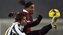Ronaldinho v dresu AC Milán bojuje o míč s obráncem Juventusu Zdeňkem Grygerou.