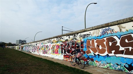 Zeď už není šedá, pokrývají ji grafitti.