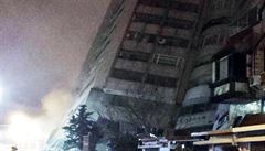 Lidé pozorující padající budovu pi zemtesení v Tchaj-wanu.