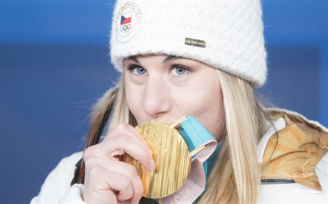 Ester Ledecká líbá svou zlatou medaili ze superobřího slalomu.