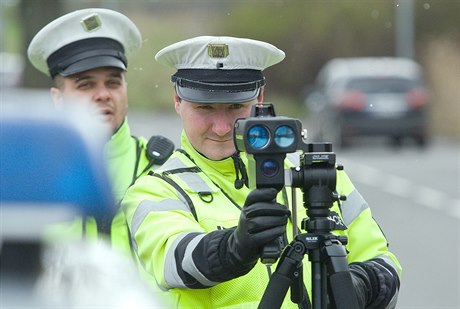 Policista s radarem mí rychlost.