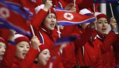 Rudomodré vlajeky povlávají nad mávajícím severokorejským publikem.