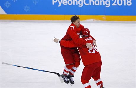 Kirill Kaprizov (vlevo) slaví zlatý olympijský gól se spoluhráem Vojnovem.