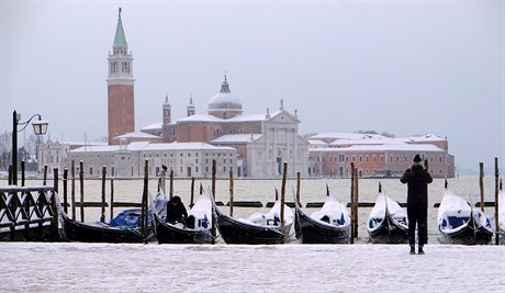 Pohled na zasnené Benátky a zamrzlé gondoly.